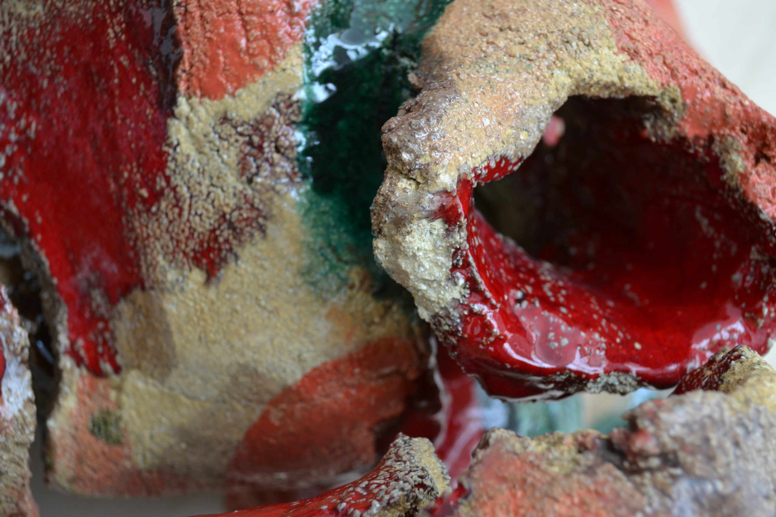 Detail of the sculpture "Corps Paysage #4" by Barbara Bauer artist, showing the glazes in red and green of the ceramic sculpture
