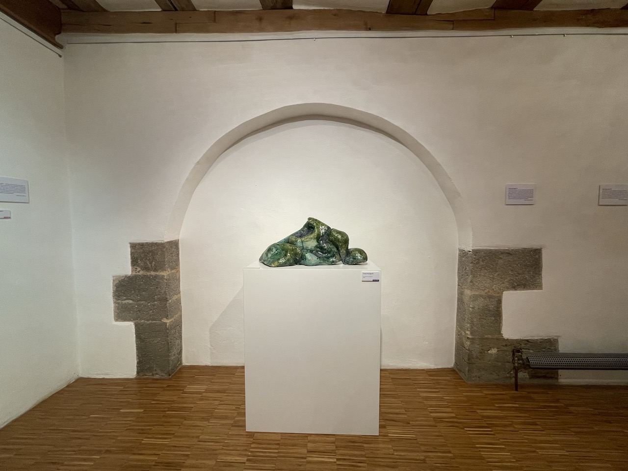 Exhibition view 2022: m / w / d, Kloster Wechterswinkel © Barbara Bauer Eine grüne Keramikskulptur der Künstlerin Barbara Bauer steht auf einem Sockel.